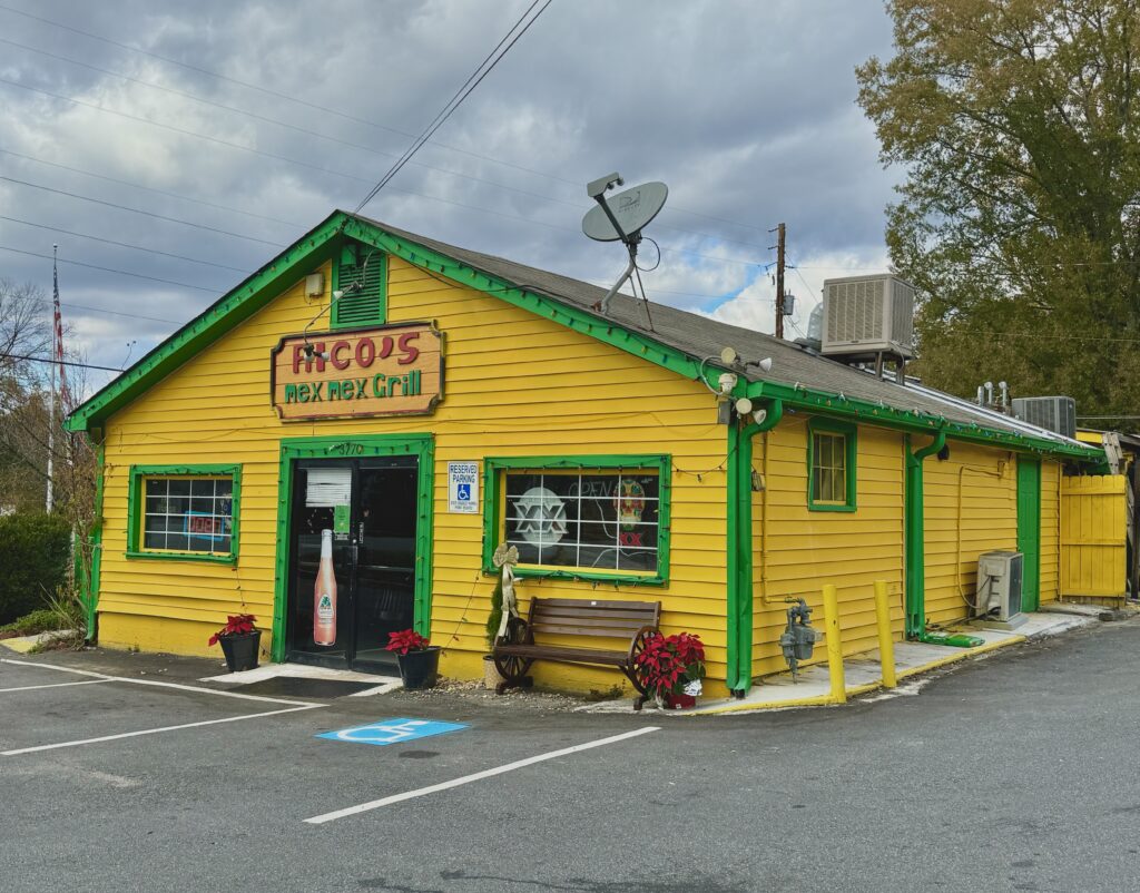 Yellow and green building with a sign reading 