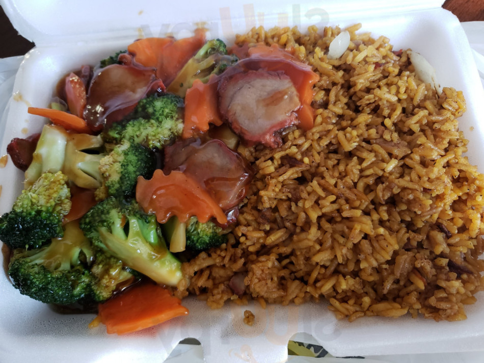 Container with fried rice, broccoli, carrots, and meat slices in sauce.