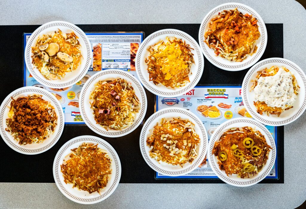 Ten plates of various pasta dishes, each featuring different toppings and sauces, arranged on a table over a colorful menu.