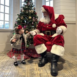 Image Santa holding Baby Girl Hand while she Stands Looking at Him