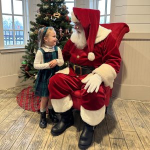 Image Santa with Little Girl Standing Beside Him Looking at Each Other