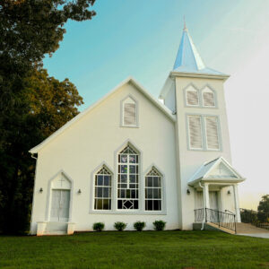 Nestled in a grassy area, the white, single-steeple church with pointed windows is flanked by trees on the left, making it one of Acworth's charming highlights. Discover why this picturesque town should be your next travel bucket list destination.