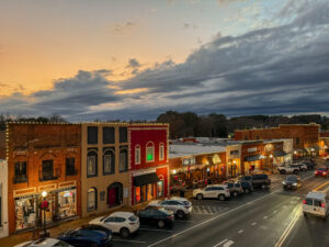 As the sun sets on Acworth's small-town main street, the illuminated storefronts invite you in, offering warmth against the cloudy sky. With parked cars lining the street, pop in and discover 6 Winter Combos for Fresh Food + a Good Mood to brighten your evening.