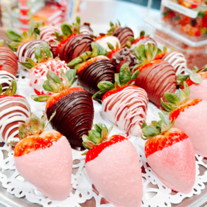 A tray of strawberries dipped in dark, white, and pink chocolate, arranged on a decorative doily—perfect for adding a sweet touch to your date at one of the 6 must-visit spots for the perfect Valentine's Day in Acworth.