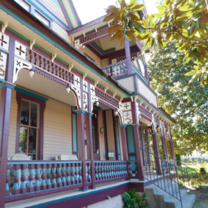 A Victorian-style house in Acworth showcases ornate trim and decorative wooden details, all elegantly painted in maroon and cream. Its multiple porches provide the perfect setting for enjoying 6 winter combos designed to keep your mood bright and your meals fresh.