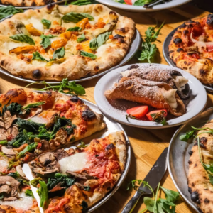 Assorted pizzas with various toppings are served on metal trays around a plate of cannoli and strawberries—a perfect spread for a weekend in Acworth.