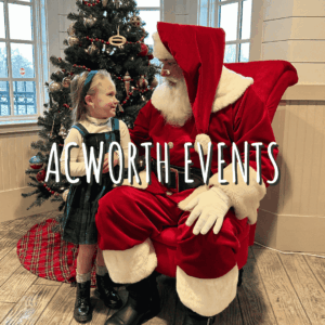 A young girl talks to Santa Claus in front of a decorated Christmas tree. Text on the image reads "ACWORTH EVENTS—Celebrate the Season in Acworth.