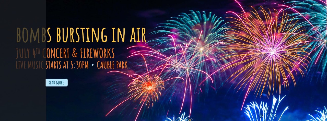 Colorful fireworks light up the night sky with event details: "Bombs Bursting In Air," July 4th concert and fireworks, live music at 5:30 PM, Cauble Park.