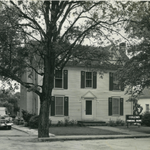 A two-story house with dark shutters and a large tree in front; a sign reads “Collins Funeral Home.” A vintage car is parked on the left. Learn More About Historic Acworth Locations at this fascinating landmark.