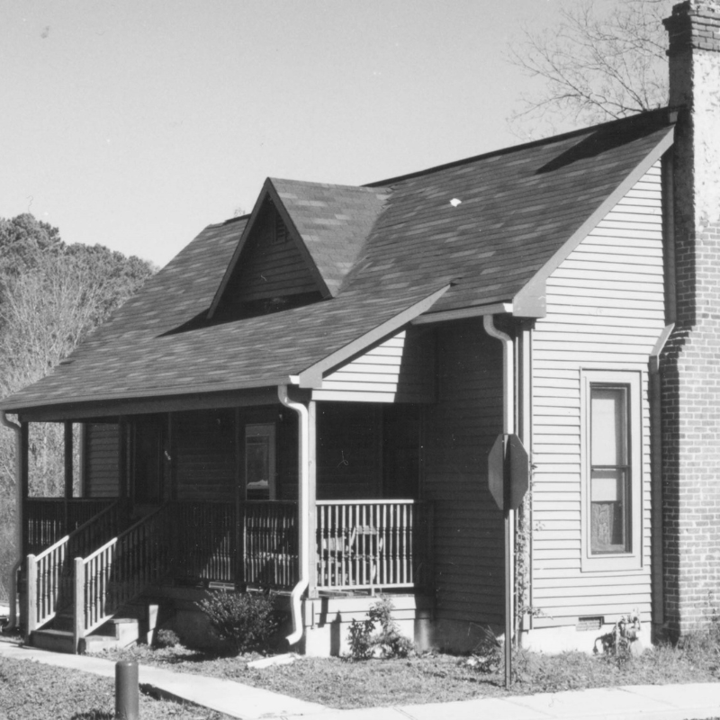 A single-story house with a covered front porch, brick chimney, and horizontal siding, photographed in black and white. Learn More About Historic Acworth Locations and discover stories behind homes like this one. A single-story house with a covered front porch, brick chimney, and horizontal siding, photographed in black and white. Learn More About Historic Acworth Locations and discover stories behind homes like this one.