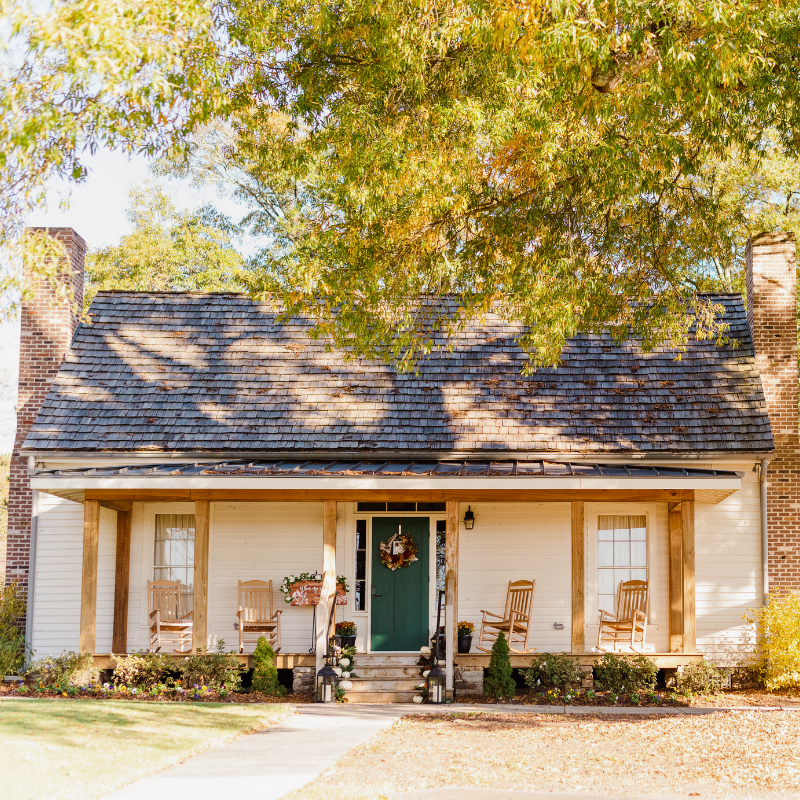 A small white house with a shingled roof, green front door, and two rocking chairs on the porch sits among autumn trees—inviting you to learn more about historic Acworth locations. A small white house with a shingled roof, green front door, and two rocking chairs on the porch sits among autumn trees—inviting you to learn more about historic Acworth locations.