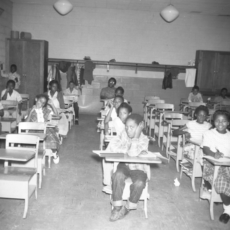 Black and white photo of children sitting at desks in a classroom. Coats hang at the back, and the students face forward, some with their hands clasped, others looking around. Learn more about historic Acworth locations through this glimpse into the past. Black and white photo of children sitting at desks in a classroom. Coats hang at the back, and the students face forward, some with their hands clasped, others looking around. Learn more about historic Acworth locations through this glimpse into the past.