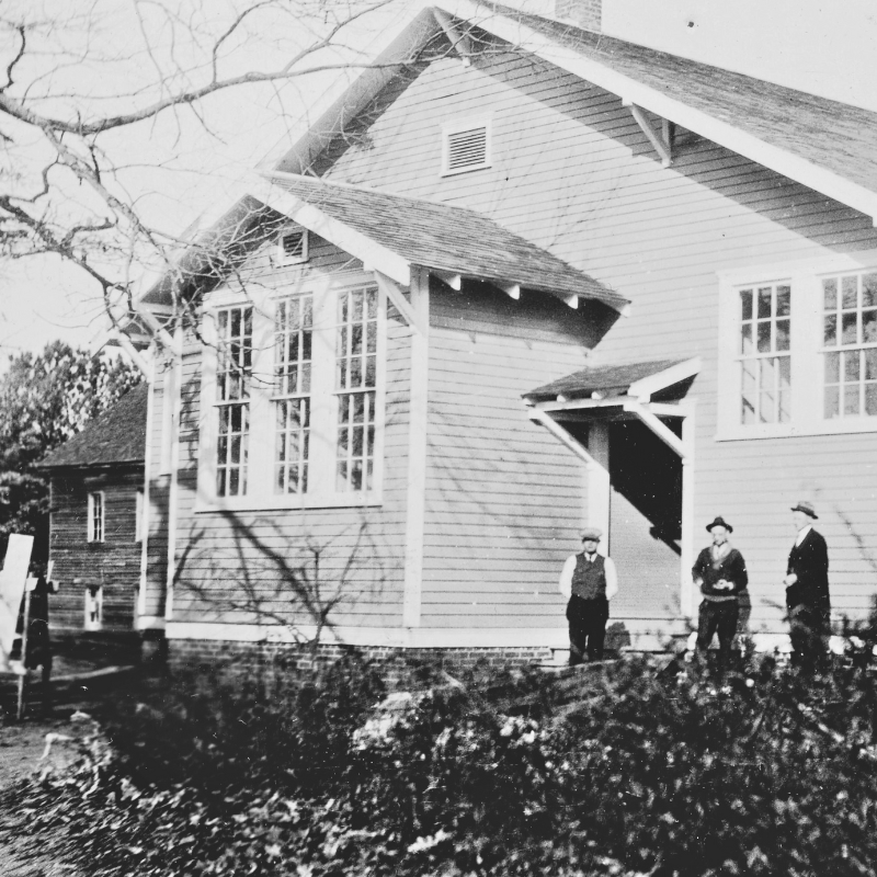 Black-and-white photo of three men standing outside a wooden building with large windows; bare tree branches are visible in the foreground. Learn more about historic Acworth locations featured in this evocative image. Black-and-white photo of three men standing outside a wooden building with large windows; bare tree branches are visible in the foreground. Learn more about historic Acworth locations featured in this evocative image.