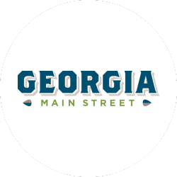 Logo with the word "GEORGIA" in bold blue letters above the words "MAIN STREET" in smaller green letters, all on a white circular background.