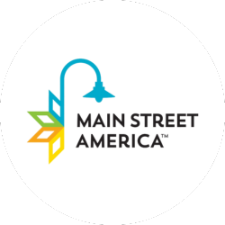 Main Street America logo with a blue lamp post and colorful geometric leaves to the left of black text reading "Main Street America.