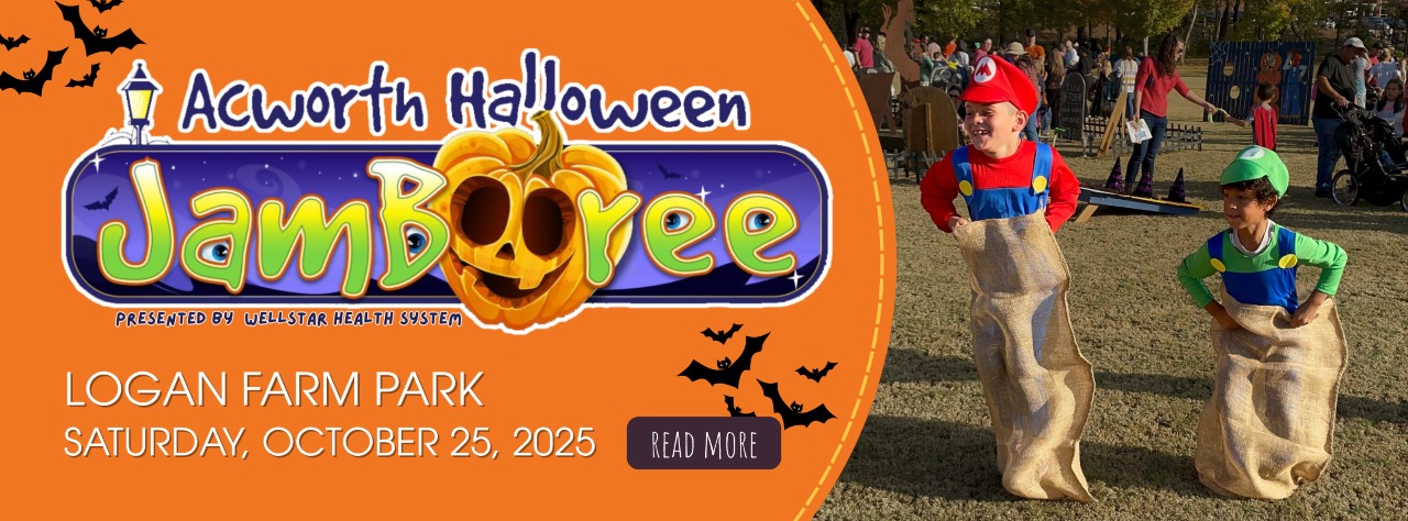 Two children in Mario costumes participate in a sack race at an outdoor Halloween event in a park with people in the background.