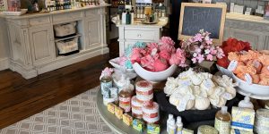 A display of bath products, including bath bombs and soaps, arranged in bowls and on tables in a boutique store with wooden floors and white furniture—perfect inspiration for your list of 26 Acworth-y Things to do in 2026.