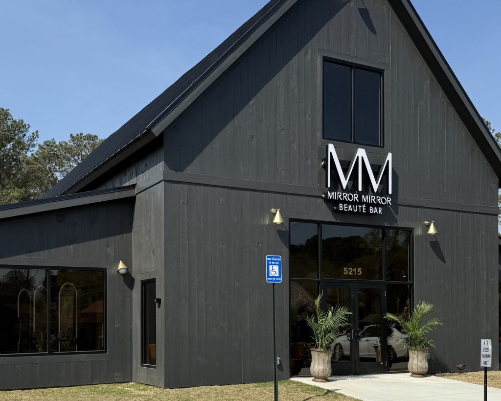 A modern dark gray building with large windows, labeled 