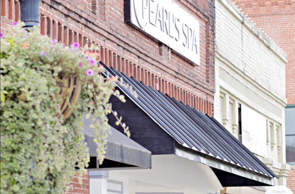 Brick storefront with a black awning and a sign reading