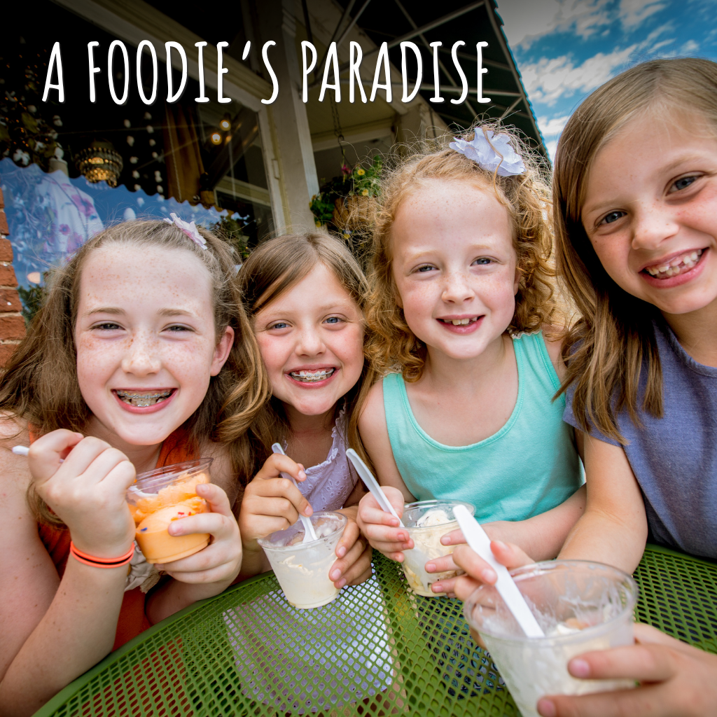 Image Four Little Girls Smiling for a Photo While Eating Ice Cream Around a Round Table Downtown
