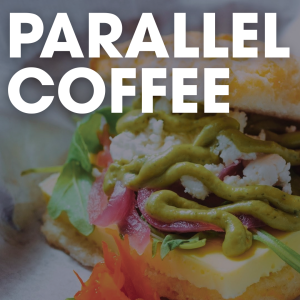 A close-up of a sandwich with greens, cheese, and sauce, overlaid with the words "PARALLEL COFFEE" in bold white letters—this is truly breakfast worth waking up for in Acworth.