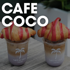 Two layered iced coffees topped with red-striped croissants, served in clear cups with a palm tree logo reading "CAFÉ DE COCO." Large text above reads "CAFE COCO." It’s truly breakfast worth waking up for in Acworth.