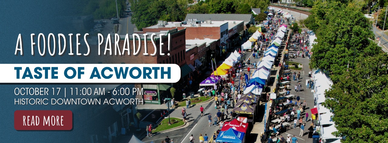 Aerial view of a crowded street festival with white tents, people walking, and storefronts, promoting the Taste of Acworth event in downtown Acworth on October 17.